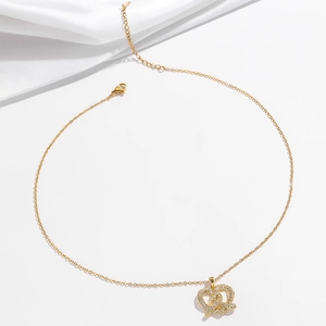 Collana a cuore pretzel dorata con cristalli scintillanti su sfondo di seta bianca