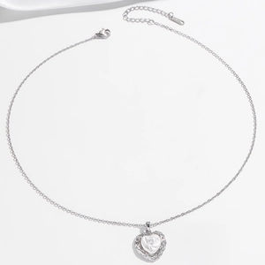 Élégant collier cœur argenté avec rose gravée et accents de perles de zircone