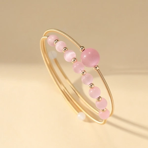 Minimalist gold multi-layered open bangle with pink crystal beads in an elegant design