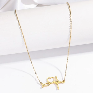Elegant gold ECG heartbeat and heart pendant necklace displayed on a white silk backdrop