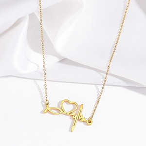 Close-up of gold stethoscope heart necklace with heartbeat pendant and polished finish