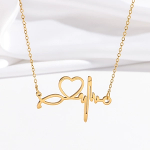 Detailed close-up of golden heartbeat heart pendant necklace on white silk background