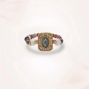 Macro shot of vintage gold ring with blue gemstone and colorful beaded band