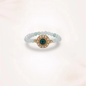 Detail of light green jade beaded ring with a gold-edged emerald-green center stone