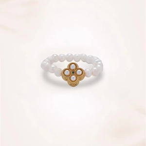 Detailed view of beaded freshwater pearl ring with golden clover and green gemstone