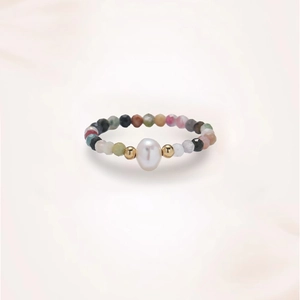 Detailed macro of a beaded ring featuring a natural pearl and multi-colored faceted stones