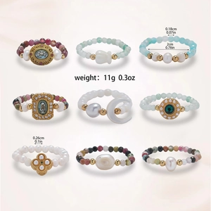 Detailed grid of freshwater pearl and gemstone beaded rings with floral metal charms