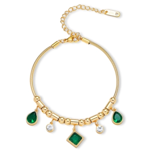Macro detail of gold snake chain bracelet with emerald teardrop stones and lobster clasp