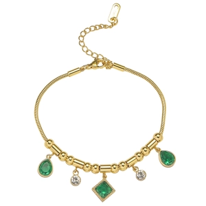 Detail of adjustable gold snake chain bracelet featuring emerald green zircon drops