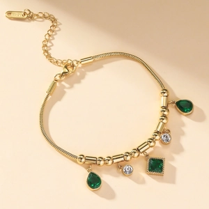 Gold-tone snake chain bracelet with emerald green zircon pendants and white diamond accents