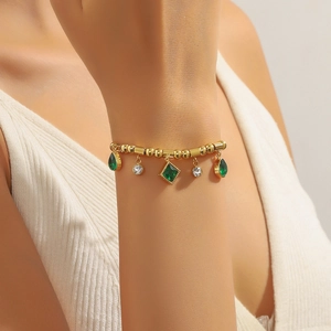 Bohemian gold beaded bracelet with emerald green drops and sparkling crystals on wrist