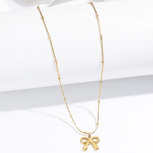 Elegante goldene Halskette mit Schleifenanhänger auf weißem Display-Sockel präsentiert