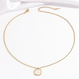 Collier en maille forçat dorée avec pendentif carré en nacre sur tissu de soie