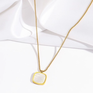 Collier élégant doré avec pendentif carré en nacre blanche sur fond de soie douce