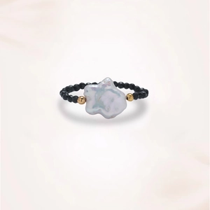 Macro detail of baroque pearl ring with black spinel beads and gold metal accents