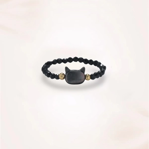 Macro shot of handcrafted black spinel ring with cat-shaped stone and gold beads