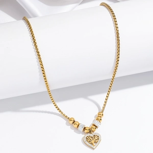 Close-up of gold heart pendant with tree of life design and sparkling zircon inlays