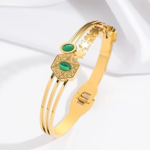 Golden celestial bangle featuring emerald green stones and hollow star patterns