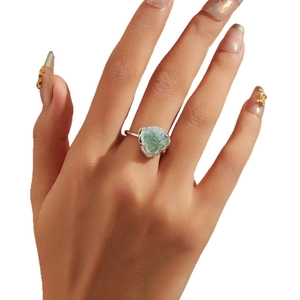 Elegant heart-shaped green emerald ring with sparkling zircon halo on silver band