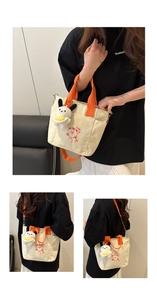 Détail du sac cabas en toile avec anses orange et breloque ours en peluche mignonne
