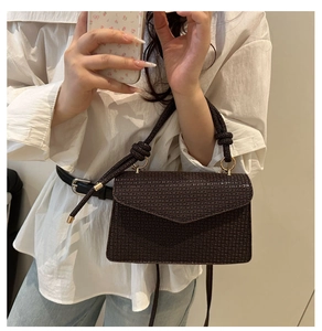 Gros plan d'un sac bandoulière marron café avec texture quadrillée et détail noué