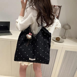 Black canvas tote bag with white star pattern and cute plush bear charm for casual use