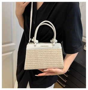 Detail der gewebten Stroh-Umhängetasche mit weißer Lederklappe und Fashion Bag-Text