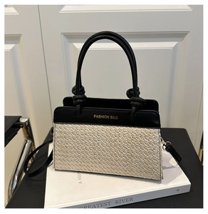 Detailaufnahme der Stroh- und Ledertasche mit goldenem Mode-Schriftzug