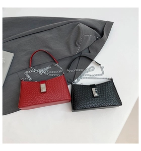 Close-up of woven texture handbags in red and black with elegant metal buckles