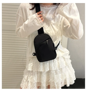 Close-up of lightweight black nylon crossbody bag with adjustable wide fabric strap