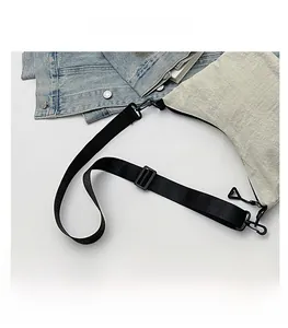 Detail of white dumpling bag with black adjustable strap and fashion letter print