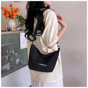 Detail of black nylon crossbody bag with fashion lettering and metallic buckle strap