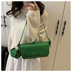 Detail of green baguette shoulder bag with matching mini pouch and leather buckle charm