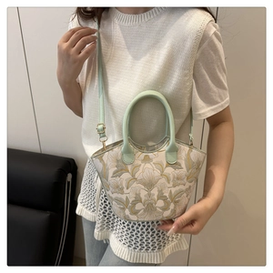 Detailed embroidery of floral patterns on a light green and white fashionable tote bag