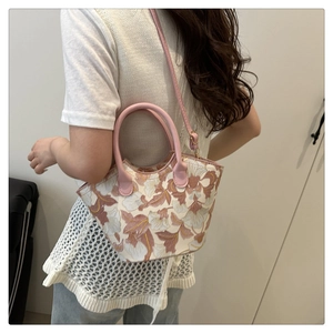 Mannequin portant un sac seau blanc avec broderie florale et poignée rose pour l'été
