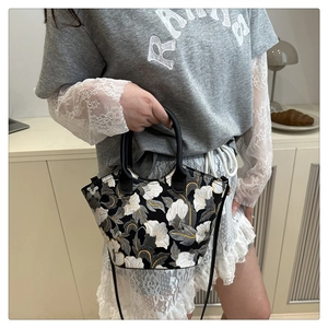 Détail de la broderie florale et de la texture sur un sac à main noir élégant