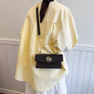 Chic black woven texture crossbody bag with gold M-logo buckle and versatile chain strap