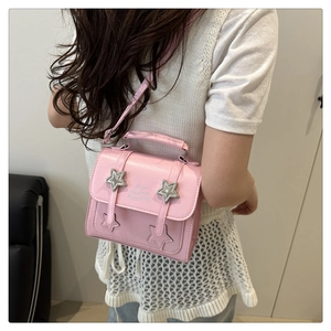 Pink crossbody bag with star buckles and Born Fashion Happiness print on the flap