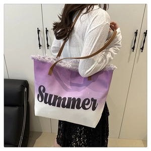Detail view of purple gradient canvas tote bag with fringed edges and leather shoulder straps