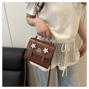 Detail of brown vintage crossbody bag featuring white star embroidery and happiness print
