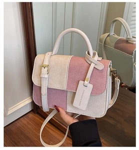 Detail shot of the contrast pink and beige patchwork bag with woven texture and charm