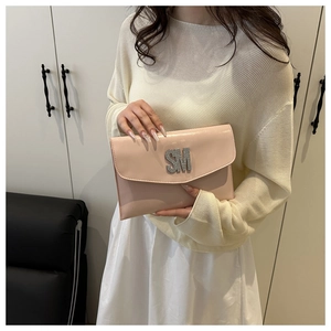 Detail of light pink patent leather envelope bag with large crystal SM logo accent