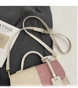 Detail of beige and rose pink contrast handbag with woven texture and adjustable strap