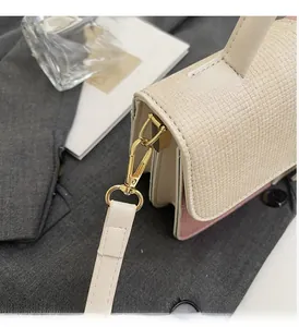 Detail of premium golden metal hardware and woven texture on a contrast color handbag
