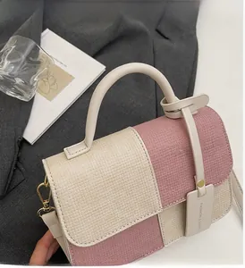 Close-up of color-block woven crossbody bag featuring cream and pink checkered pattern