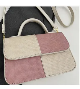 Detail of pink and beige patchwork woven handbag with golden hardware and shoulder strap