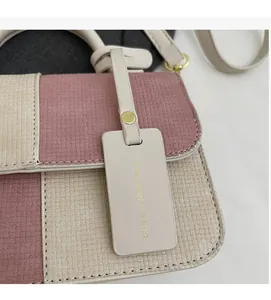 Detailed close-up of the pink and beige patchwork fabric texture and gold-lettered tag