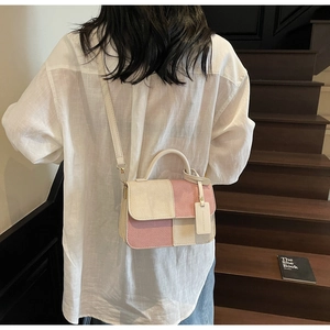 Detail of pink and beige patchwork woven bag with round handle and shoulder strap