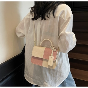 Detailed view of pink and beige checkered crossbody bag worn by a model in soft light
