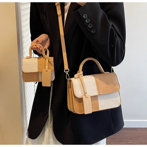 Detail view of two-tone canvas handbags set with leather trim and gold chain straps